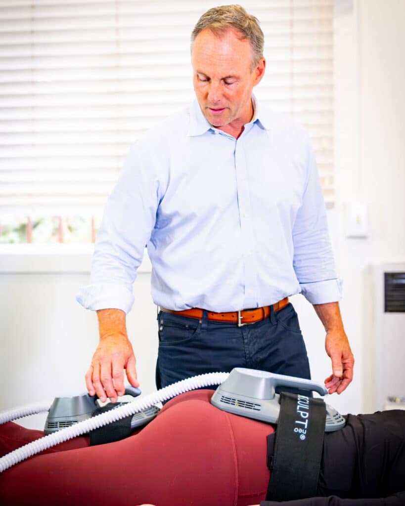 Provider administering EMSCULPT Neo treatment on patient’s abdomen and thighs at aesthetic clinic in Montecito