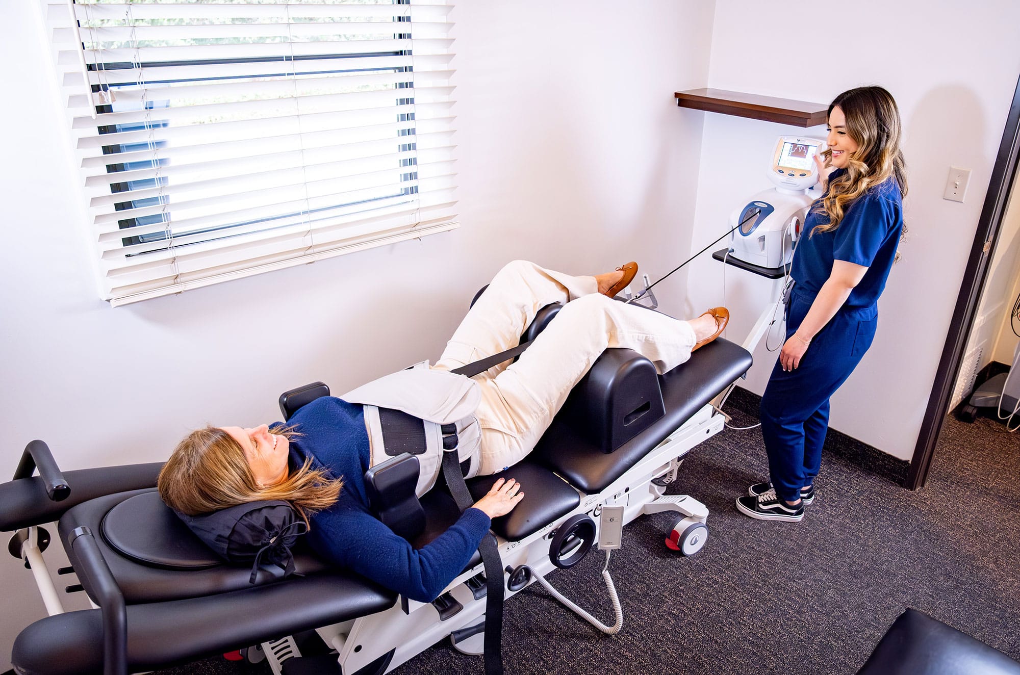 Patient receiving spinal decompression therapy under clinician supervision.