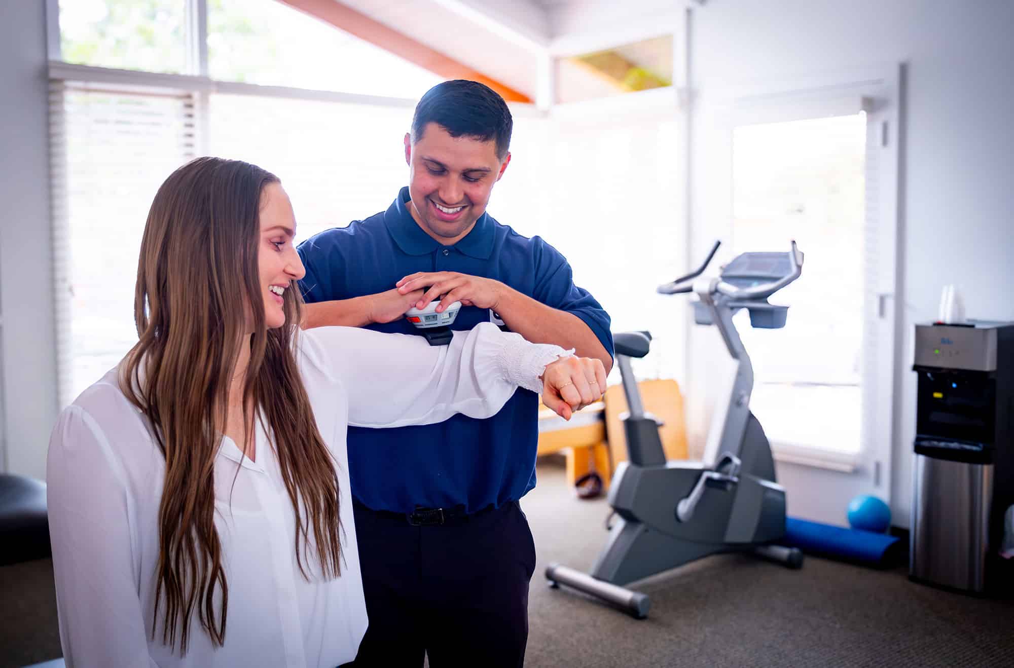 Clinician measuring a patient's shoulder strength during rehabilitation.