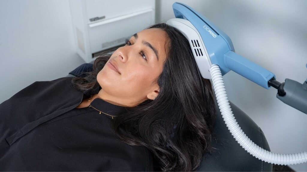 Person receiving an Exomind neurostimulation treatment while reclining in a chair at a wellness clinic in Santa Barbara.