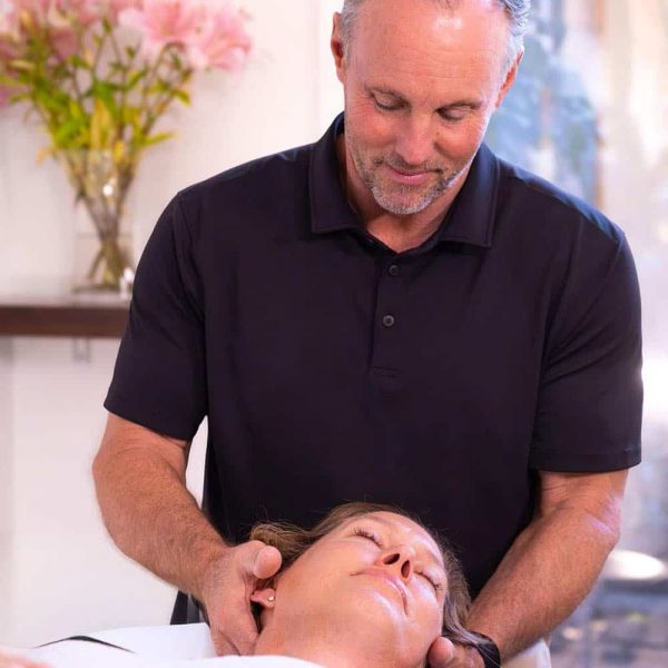 Chiropractor performing gentle neck adjustment on patient in Santa Barbara clinic