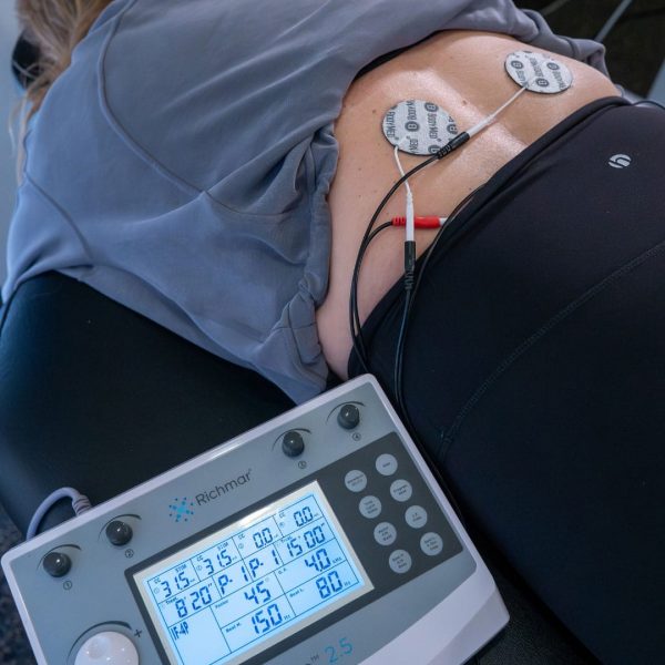 Electrical stimulation therapy applied to lower back for pain relief treatment
