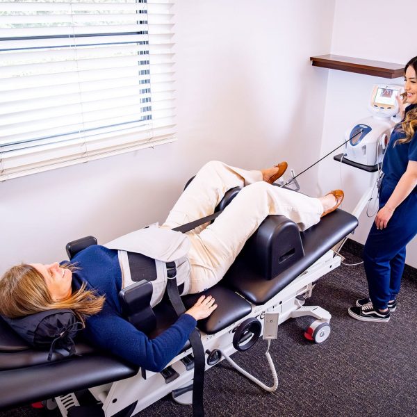 Provider administering non-surgical spinal decompression therapy for back pain in Santa Barbara clinic